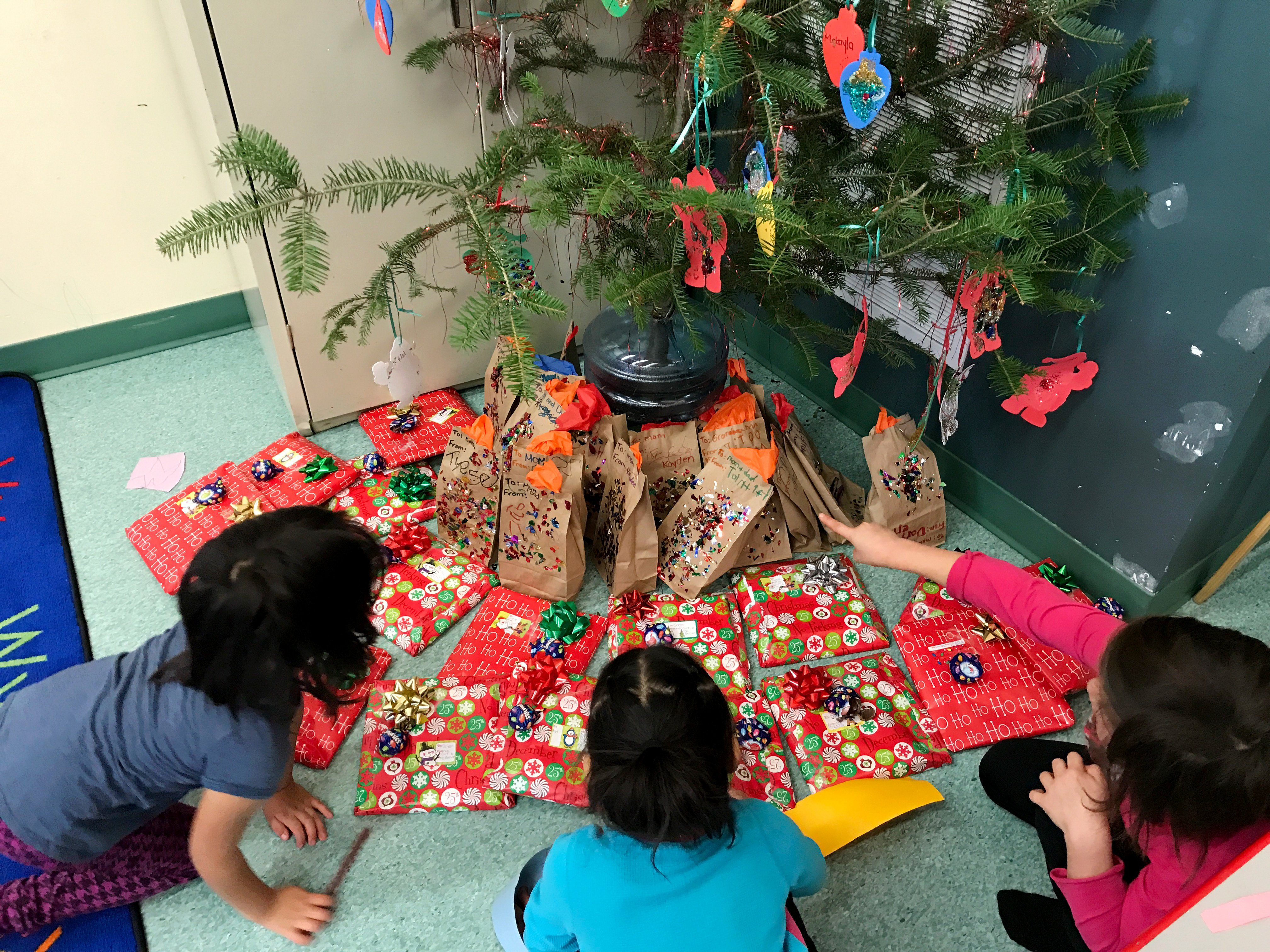 Students admire the presents under the Christmas tree