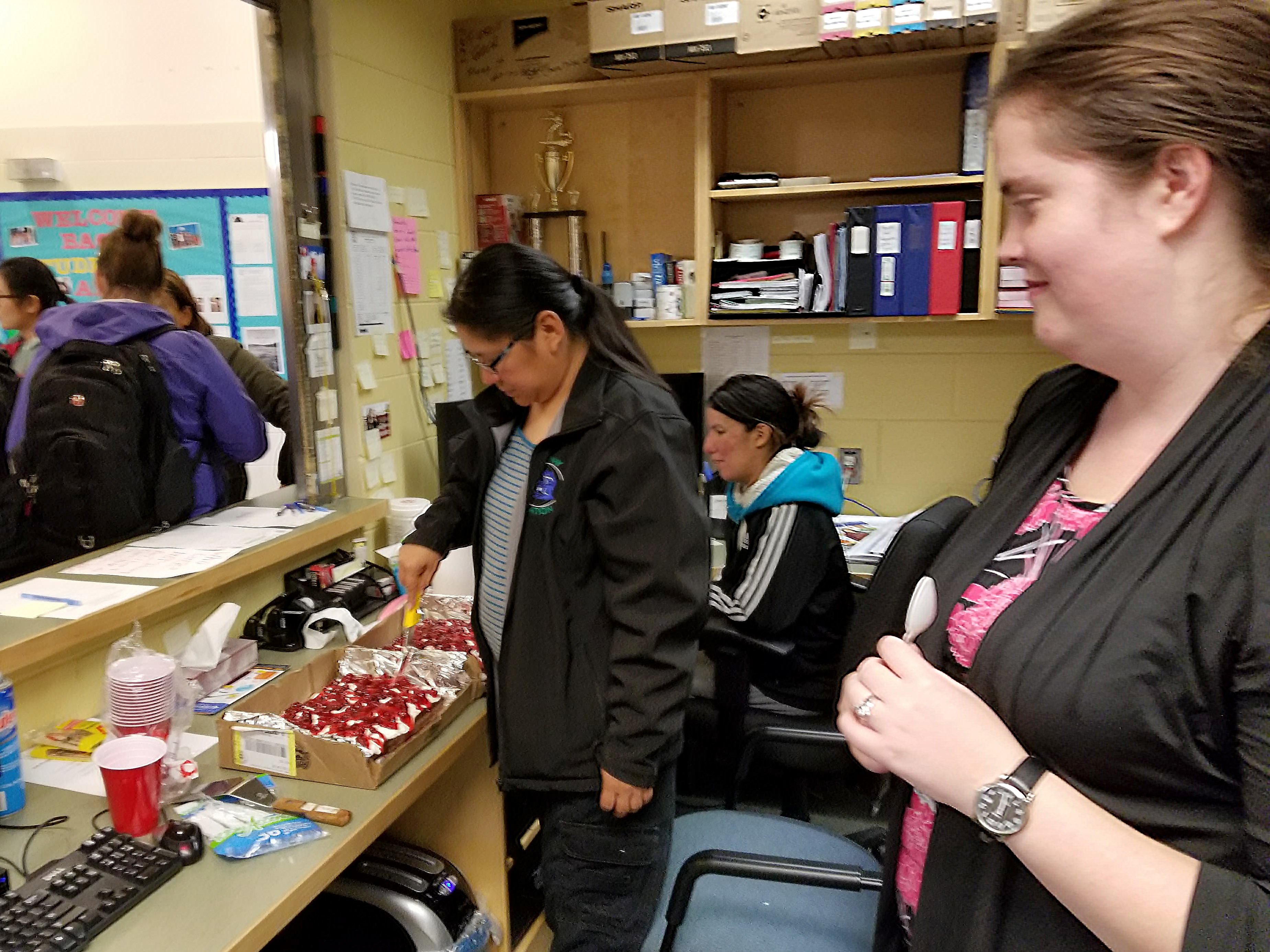 School staff celebrating Kelly's birthday with a cake