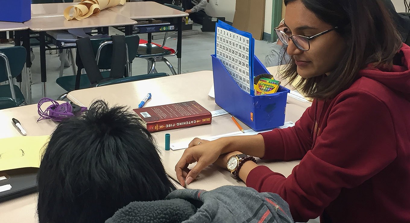 Teach For Canada teacher Gurpreet Flora working with a student in Deer Lake First Nation